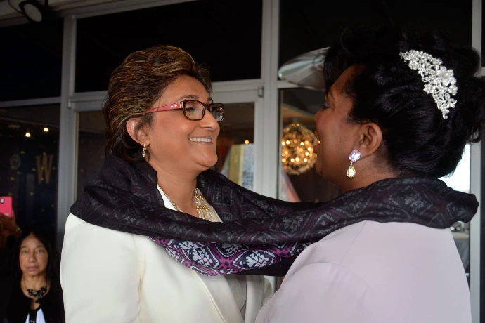 interracial lesbian couple smiling at each other during wedding